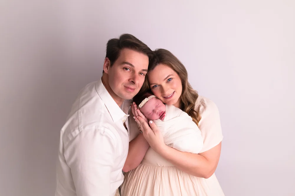 sleeping newborn wrapped in neutral fabric during studio session